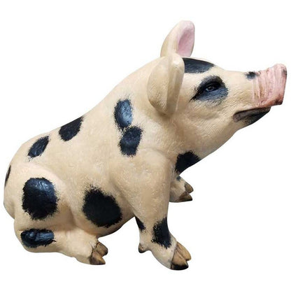 Cast aluminum spotted pig statue for garden or yard decor, featuring black spots and pink snout