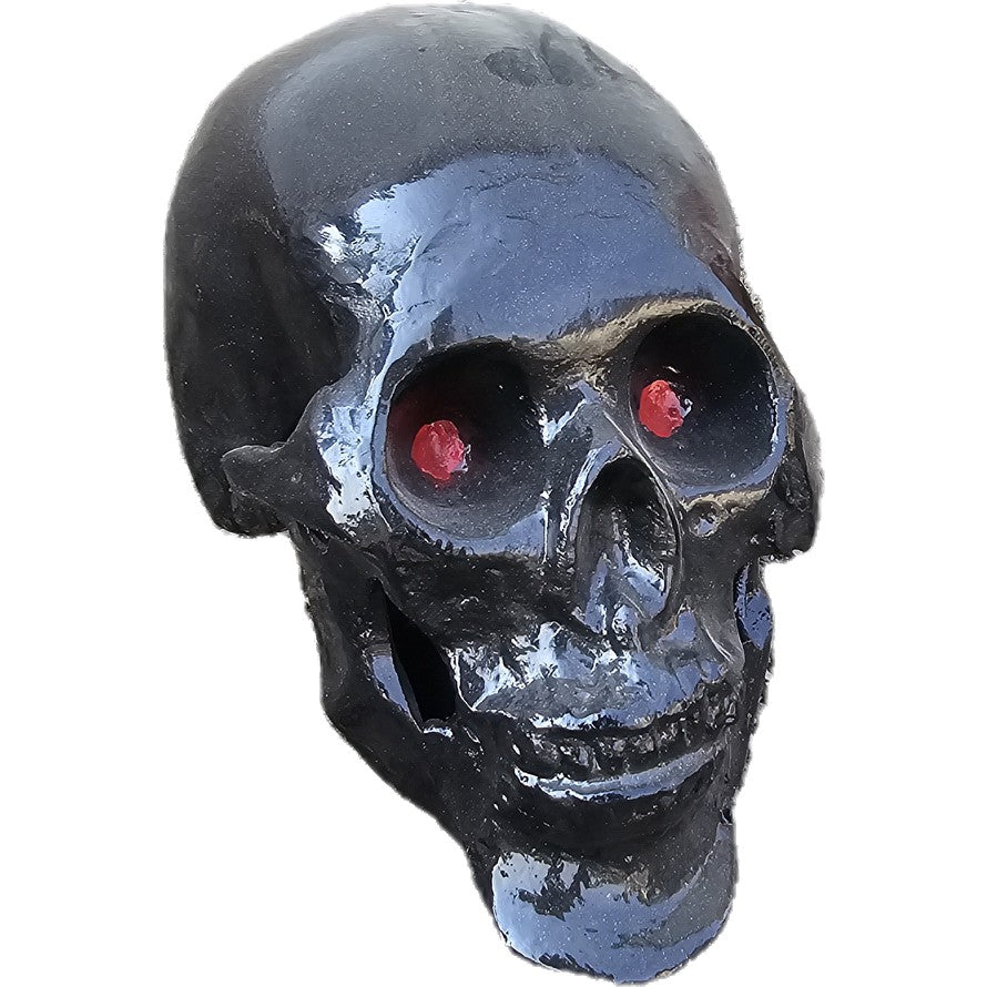 Black cast aluminum skull statue with glowing red eyes for yard or home decor