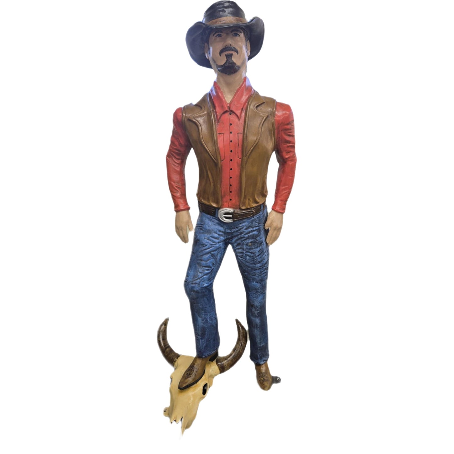 Cowboy statue in hat, red shirt, vest, standing on bull skull for yard decor