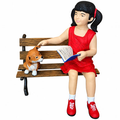 Cast aluminum girl reading and sitting on a bench with a dog.