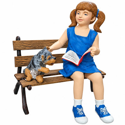 Cast aluminum girl reading and sitting on a bench with a dog.