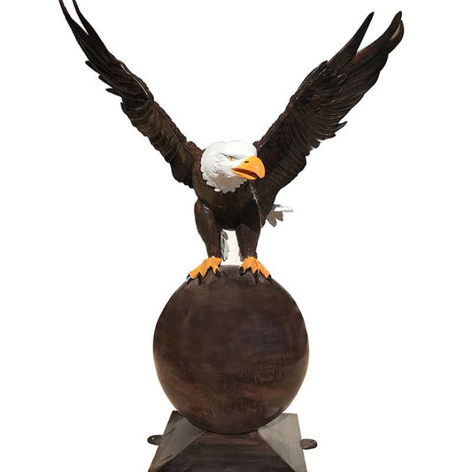 Cast aluminum bald eagle statue with wings spread, perched on sphere for yard or home decor