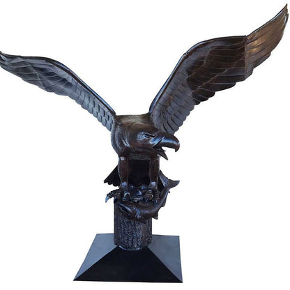 Cast aluminum eagle statue with wings spread, perched on tree stump base for yard or home decor