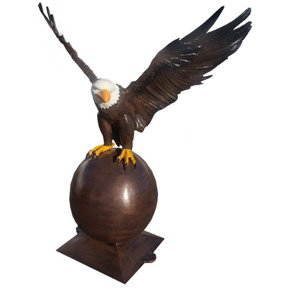 Cast aluminum bald eagle statue with wings spread, perched on sphere for yard or home decor