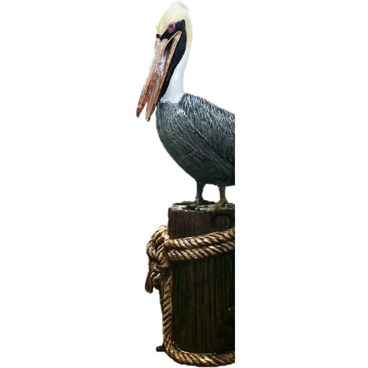 Cast aluminum pelican statue perched on rope-wrapped post for yard or home decor