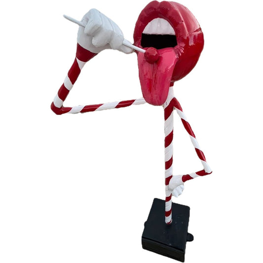 Candy cane-themed statue with red lips, tongue, and striped limbs, perfect for yard or home decor.