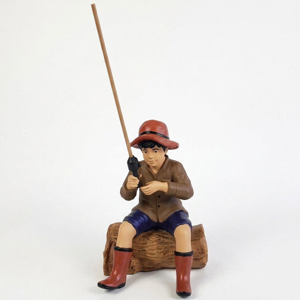 Cast aluminum fishing boy sitting on log for outdoor yard and gardens