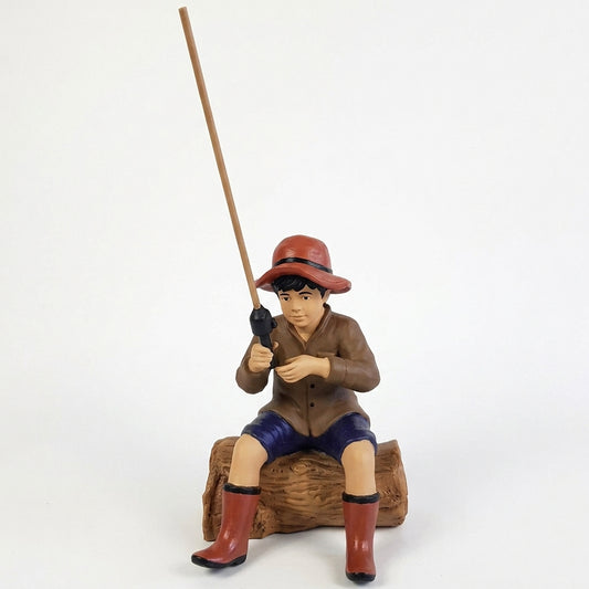 Cast aluminum fishing boy sitting on log for outdoor yard and gardens