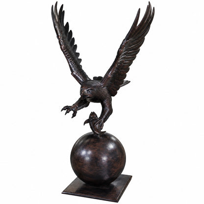Cast aluminum bald eagle statue with outstretched wings perched on fish atop globe base for yard decor